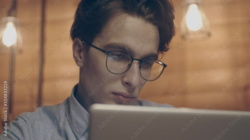 Young man working with laptop at loft apartment, close up, slow motion Young man working with laptop at loft apartment, close up, slow motion