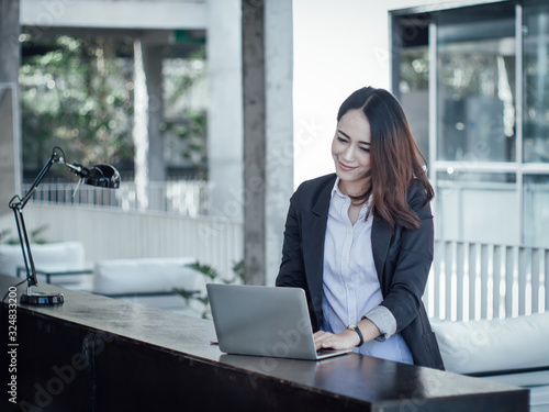 Asian business woman with laptop happy and smile concept success work