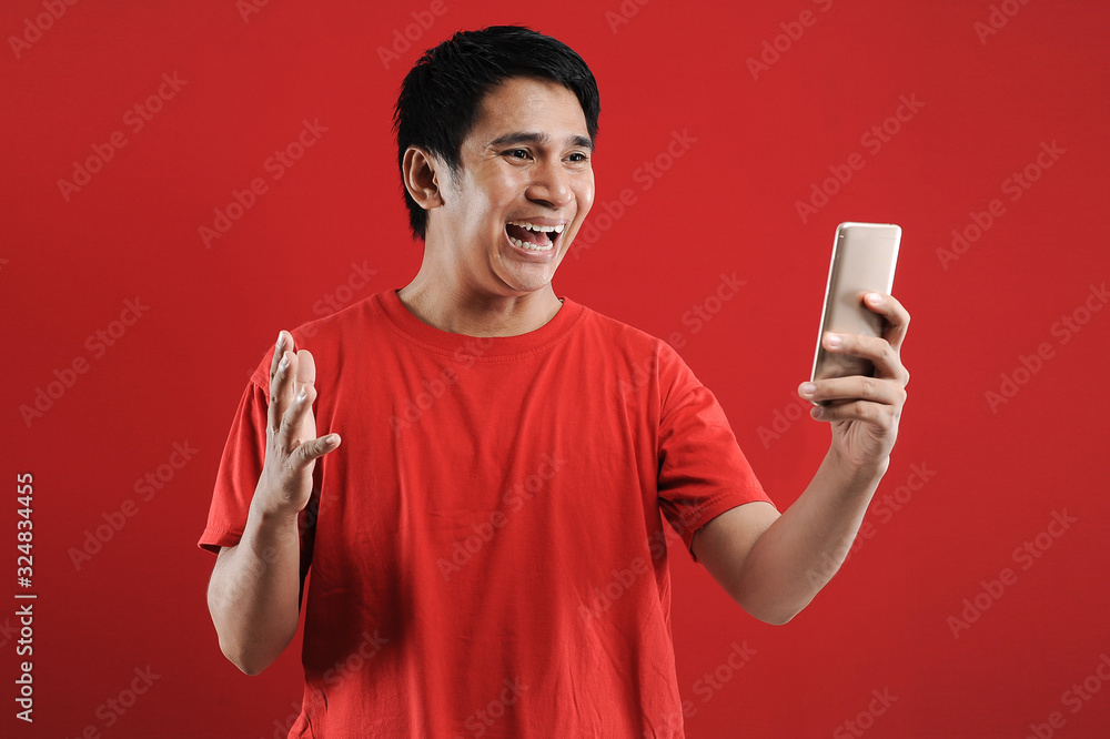 Happy Asian man reading new text on mobile Happy Asian man reading new text on mobile