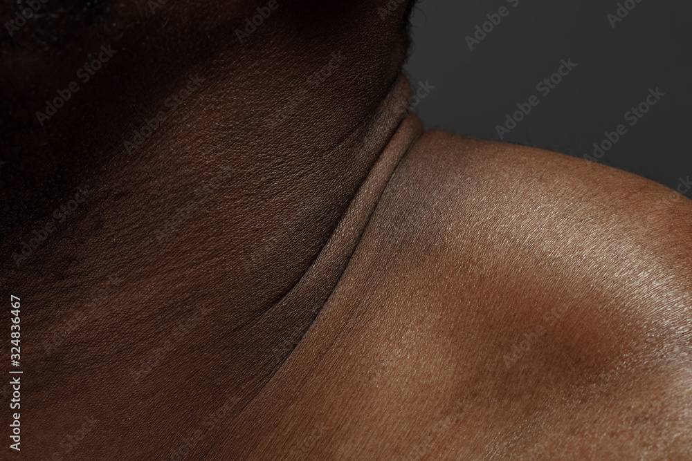 Fototapeta premium Neck. Detailed texture of human skin. Close up shot of young african-american male body. Skincare, bodycare, healthcare, hygiene and medicine concept. Looks beauty and well-kept. Dermatology.