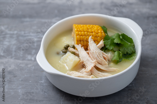 soup potato with corn and chicken in white bowl on ceramic background photo