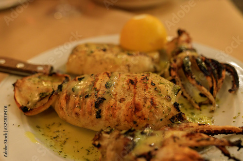 grilled squid on a plate with lemon
