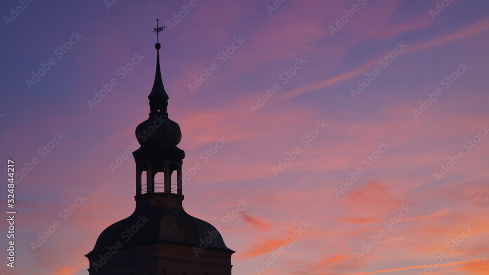 silhouette of the tower on the background of the sunset sky painted purple and pink colors