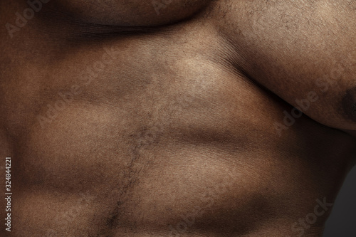 Belly. Detailed texture of human skin. Close up shot of young african-american male body. Skincare, bodycare, healthcare, hygiene and medicine concept. Looks beauty and well-kept. Dermatology.
