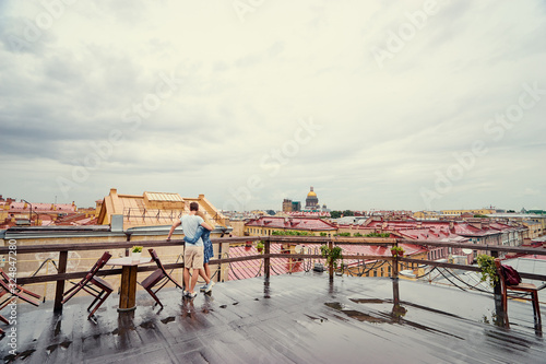 Romantic dating on the rooftop. Loving couple enjoying city view at rainy day. Saint Peterburg  Russia.