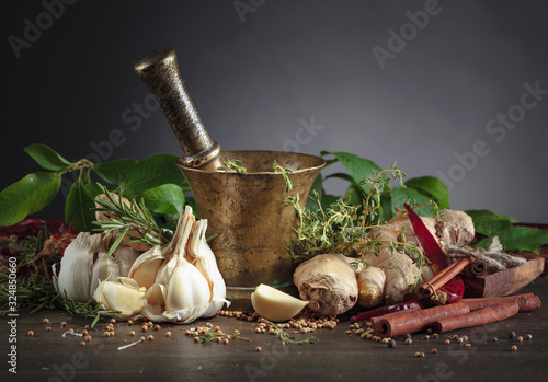 Mortar with herbs and spices on a old wooden table. photo