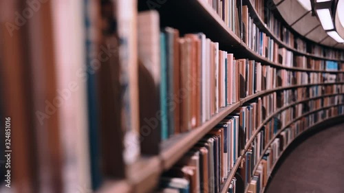 Stedicam shot. Camera moves forward along shelves filled with paper books. The huge round library in Stockholm, Sweden