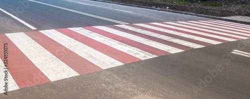 red stripes of a pedestrian crossing on asphalt
