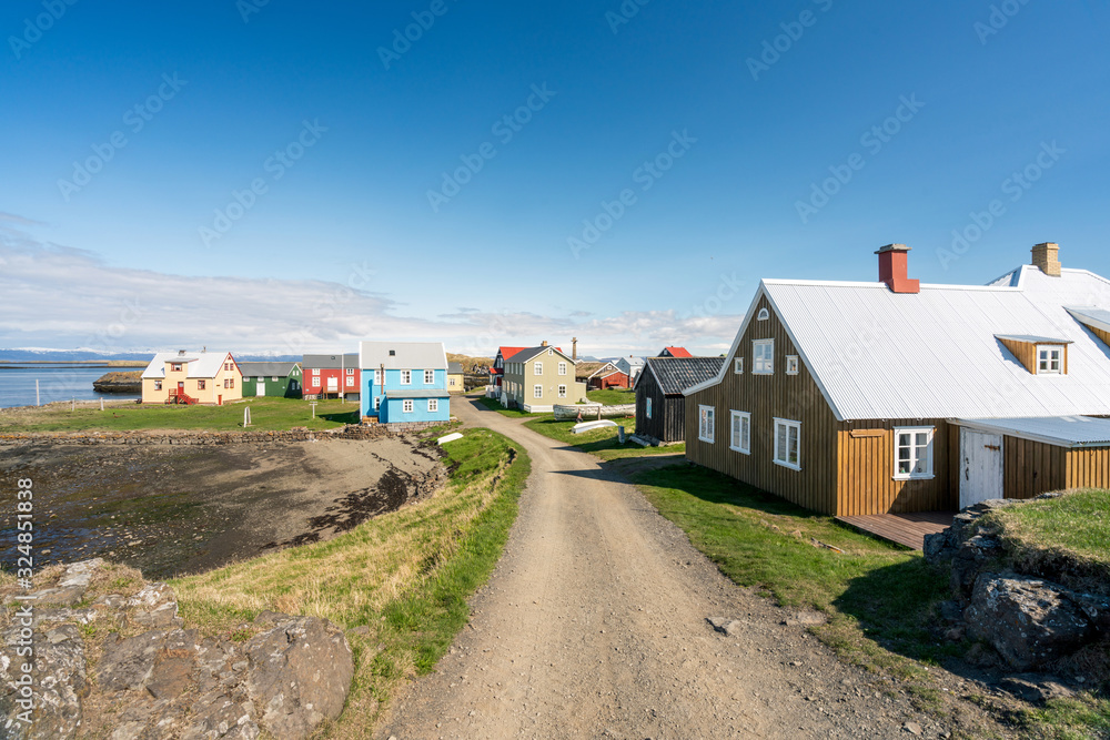 Colorful buildings and the charming city of Flatey Island in Iceland just outside Stykkisholmur and the Westfjords. Blue sky and sunny weather. Explore and traveling concept