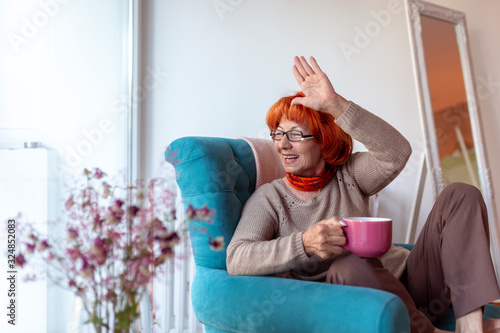 Senior woman waving through the window photo