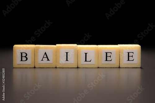 The word BAILEE written on wooden cubes isolated on a black background... photo