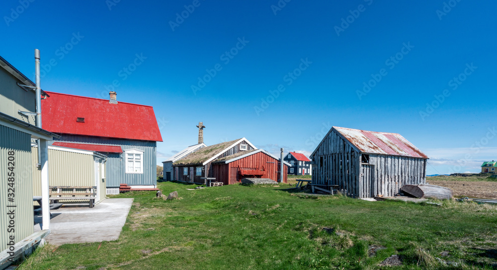 Colorful buildings and the charming city of Flatey Island in Iceland just outside Stykkisholmur and the Westfjords. Blue sky and sunny weather. Explore and traveling concept Colorful buildings and the charming city of Flatey Island in Iceland just outside Stykkisholmur and the Westfjords. Blue sky and sunny weather. Explore and traveling concept