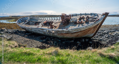Stranded old and rusty whaling ship wreck on the beach in Flatey Island just outside of Stykkisholmur and the Westfjords of Iceland. Transport and weather concept.
