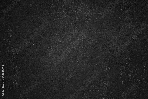 Abstract black painted stony texture of a rocky plastered wall surface for backgrounds.