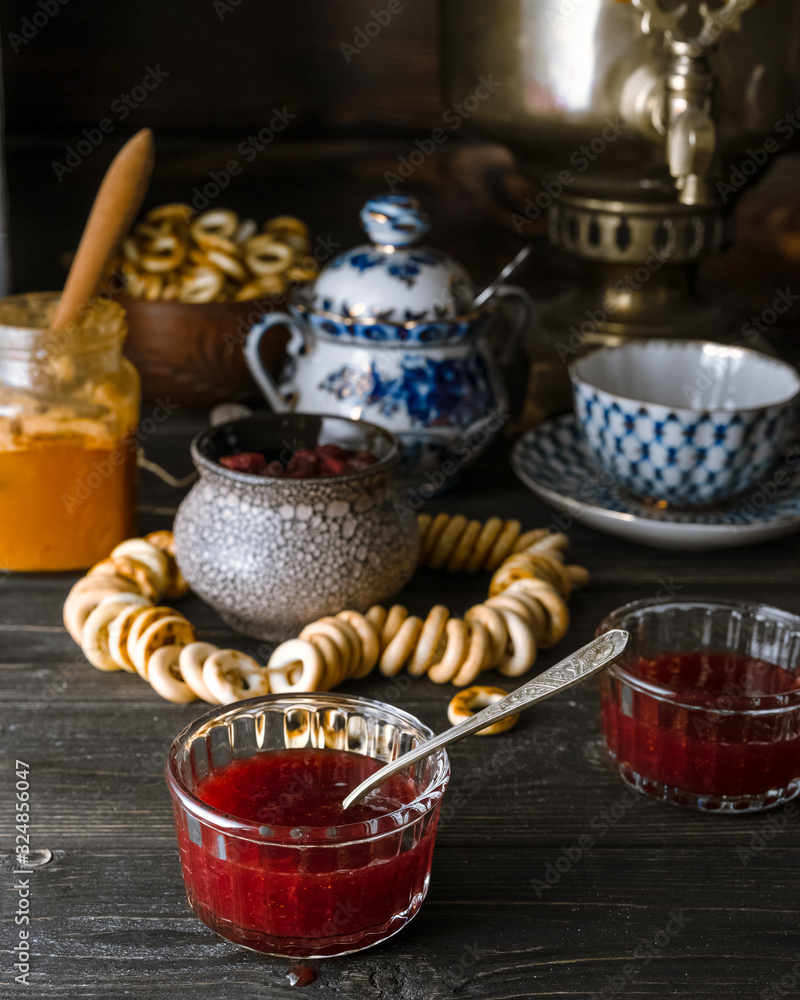 Traditional Russian tea table setup with jam, honey, bagels on dark rustic background Traditional Russian tea table setup with jam, honey, bagels on dark rustic background