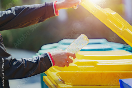 hand holding garbage bottle plastic putting into trash for cleaning photo