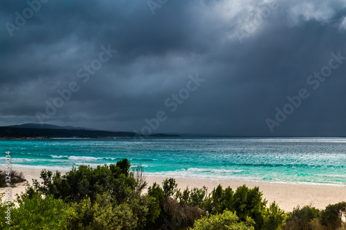 Dark clouds over turquoise waves Tasmania Australia