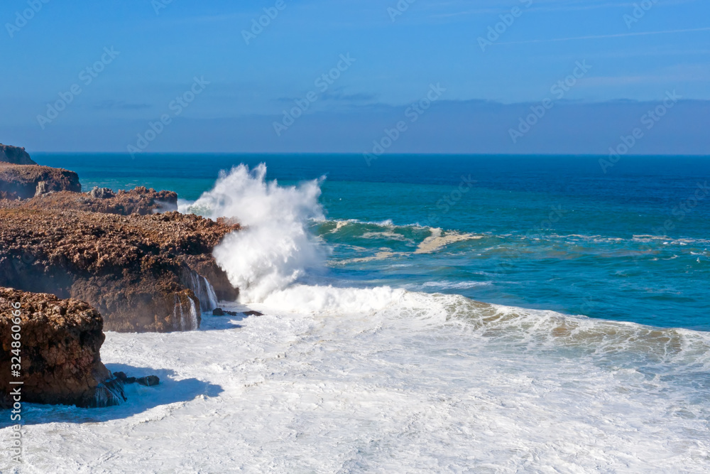 Aerial from waves smashing on the rocks at Carapateira beach in Portugal