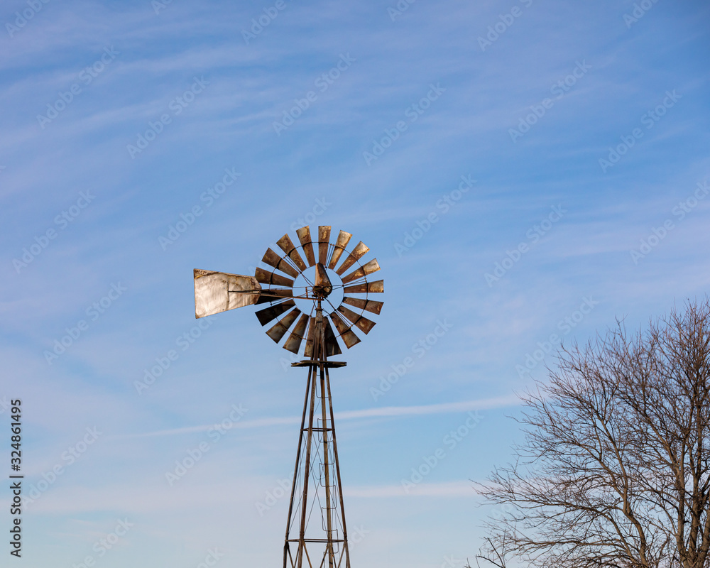 Old antique windmill, wind pump with rusty blades, vanes or sails on Midwest farm Old antique windmill, wind pump with rusty blades, vanes or sails on Midwest farm