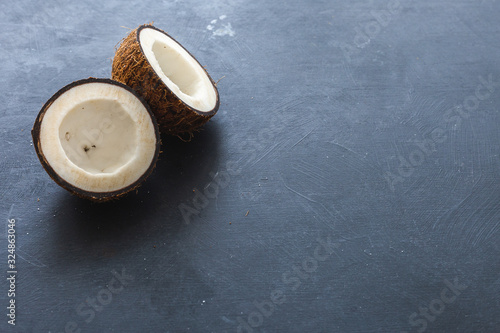 Sliced coconut on a dark table. Flat lay scene for copy space and background.