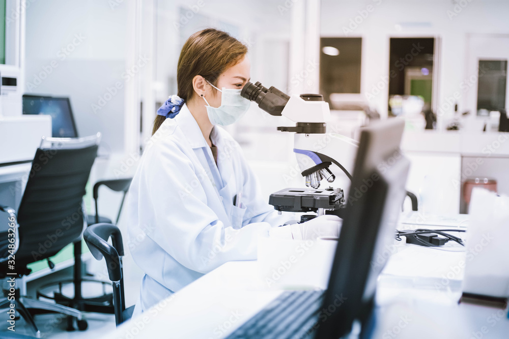 medical technician look at the microscope in medical laboratory medical technician look at the microscope in medical laboratory