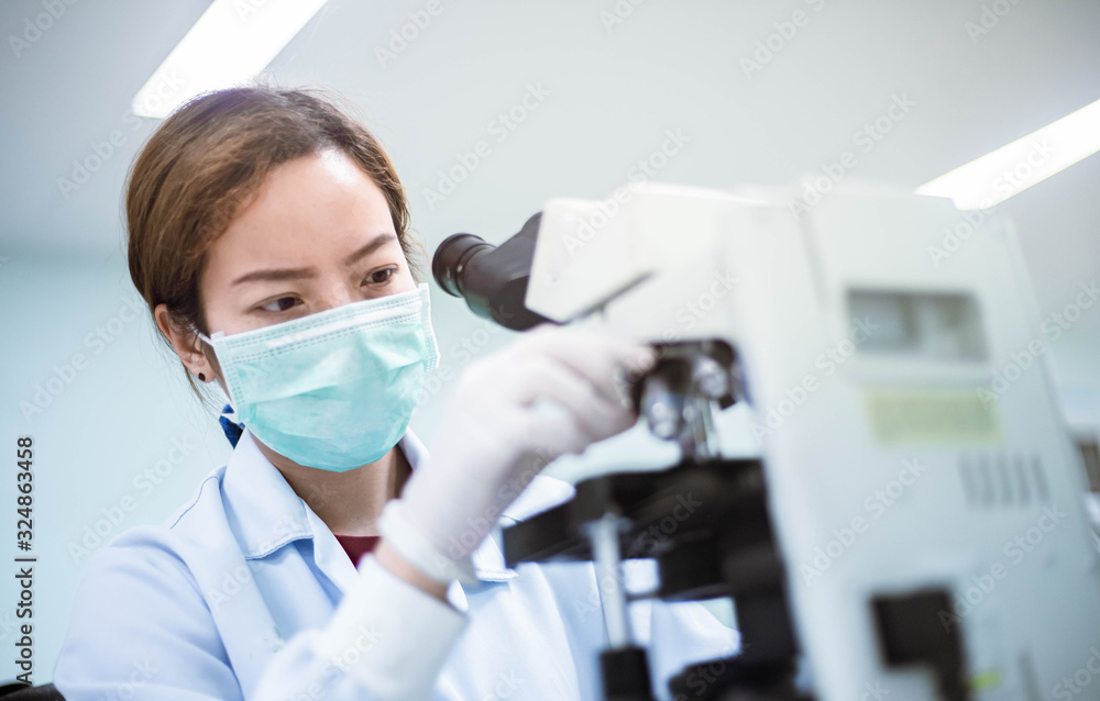 medical technician look at the microscope in medical laboratory medical technician look at the microscope in medical laboratory
