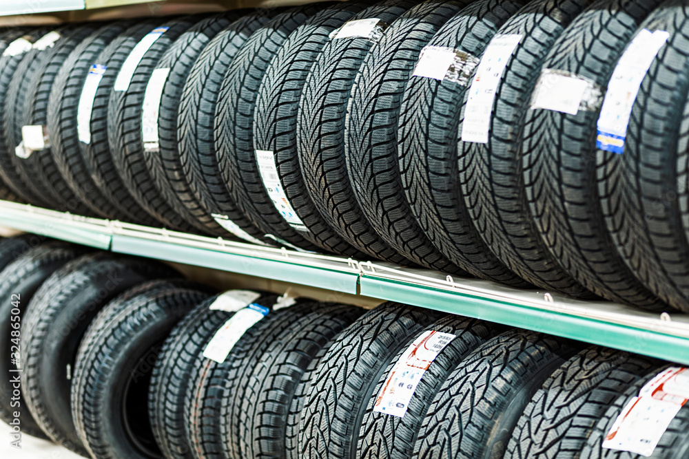 Car new tires stacked in rows in the store Car new tires stacked in rows in the store
