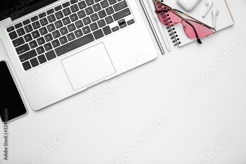 Devices, eyewear. Flat lay, mock-up. Feminine home office workspace, copyspace. Inspiring workplace for productivity. Concept of business, fashion, freelance, finance, artwork. Trendy pastel colors.