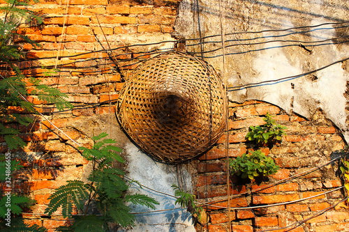 Chinese straw hat hung on the old wall