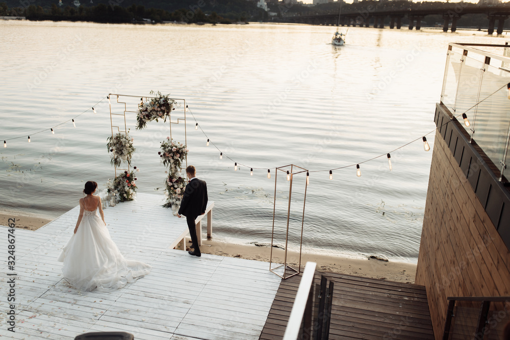 Obraz premium Portrait of wedding couple on sunset near the river