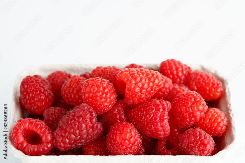 Freshly picked organic raspberries in recycled paper cup. High resolution, white background Freshly picked organic raspberries in recycled paper cup. High resolution, white background