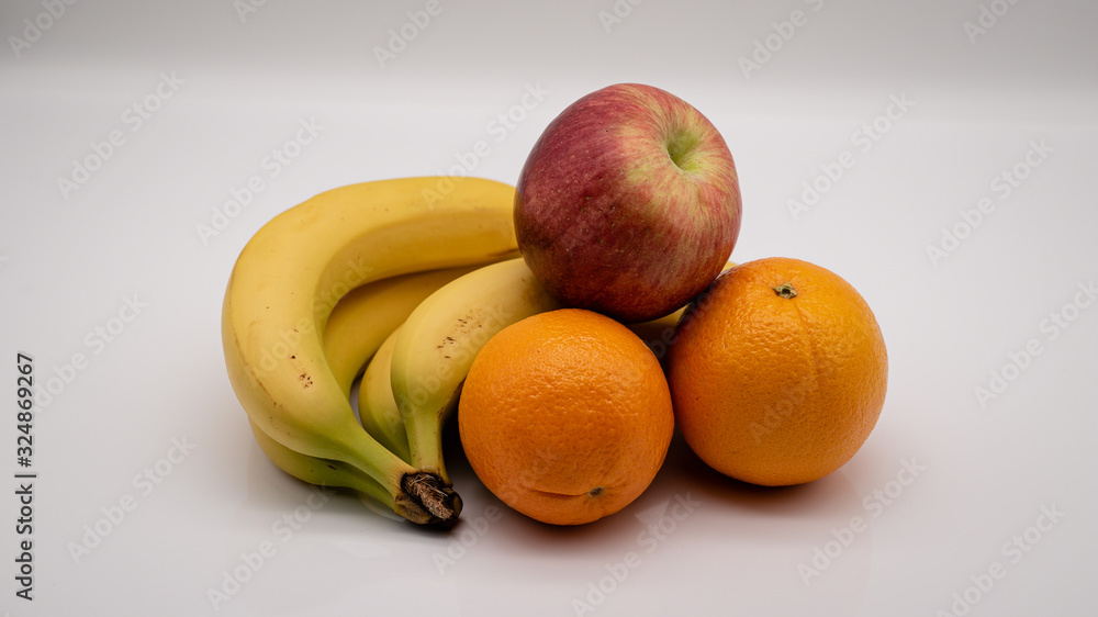 Bananen, Orangen und Apfel auf weißem Hintergrund Bananen, Orangen und Apfel auf weißem Hintergrund