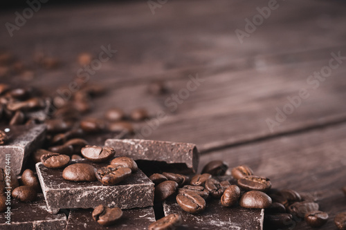 Dark chocolate with coffee beans on a dark wooden background. Sweet dessert.