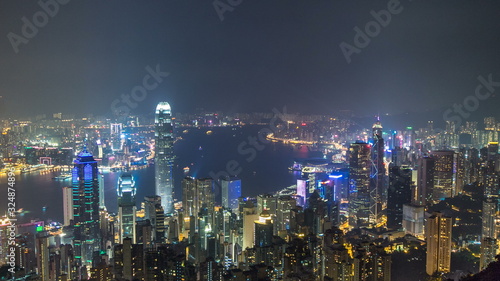 Canvas Print Hong Kong city skyline timelapse at night with Victoria Harbor and skyscrapers illuminated by lights over water viewed from mountain top