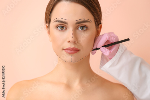 Plastic surgeon applying ma...
