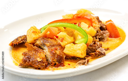 Kaeng Phed Ped Yang (Roasted Duck in Red Curry) , There is a pineapple, tomato and sliced bell pepper on top , Thai food.
