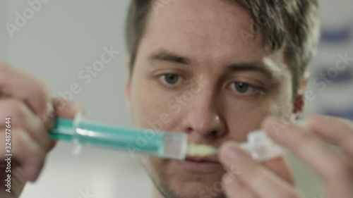 YoungDoctor preparing syringe in hospital photo