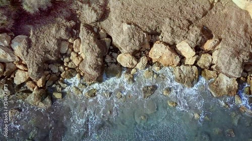 Waves are washing on stones and pebbles on the shore 4. Slow motion.