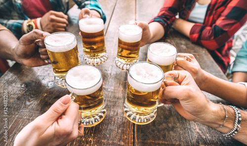 Friends hands toasting beer pints at brewery pub restaurant - Beverage concep...
