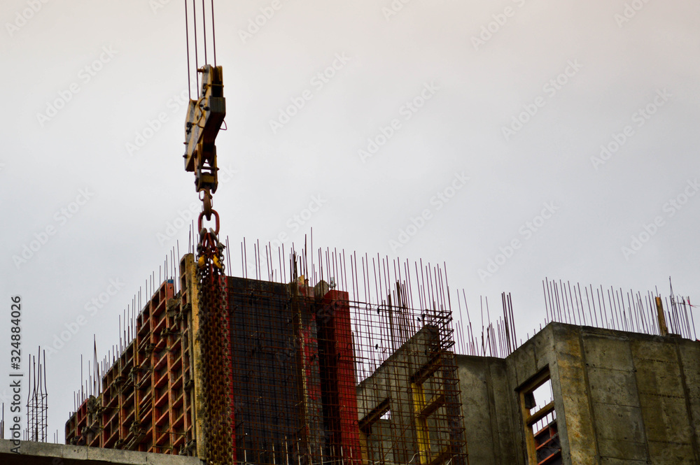 The process of construction and repair of a new modern cement concrete stone pannel monolithic frame-block building of a house with iron reinforcement at an industrial construction site The process of construction and repair of a new modern cement concrete stone pannel monolithic frame-block building of a house with iron reinforcement at an industrial construction site