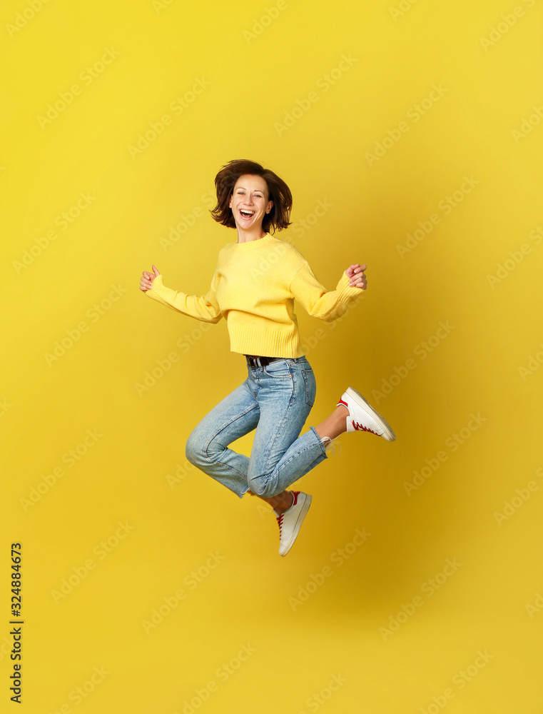 Beautiful woman jumping on yellow background Beautiful woman jumping on yellow background
