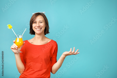 Beautiful woman holding cocktail on  blue background