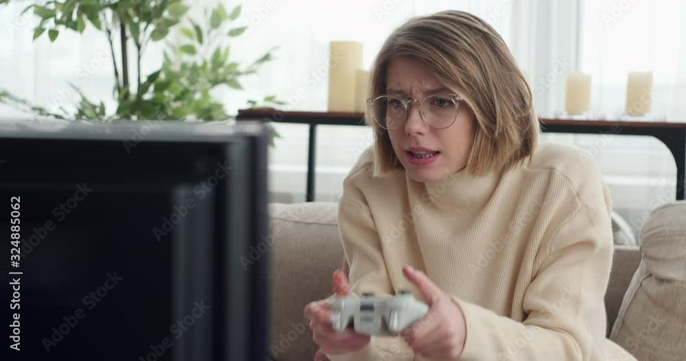 Excited woman celebrating win playing a video game at home Excited woman celebrating win playing a video game at home