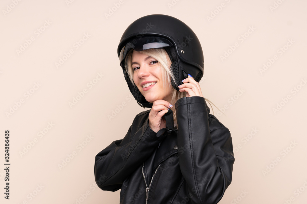 Young blonde woman with a motorcycle helmet over isolated background Young blonde woman with a motorcycle helmet over isolated background