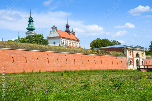 Fortifications of the fortress and city of Zamość. View on the walls of fortress and Szczebrzeska Gate.  In background is Cathedral of the Resurrection and Saint. Thomas the Apostle in Zamosc. Poland. photo