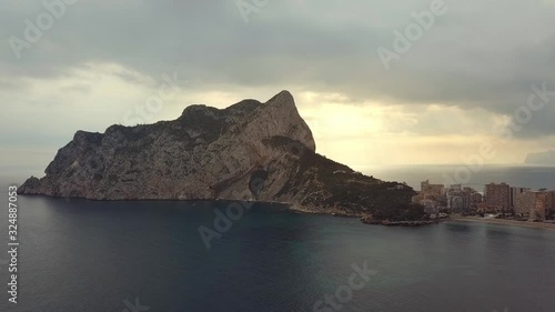Aerial view big rock near Parque natural del Penon de Ifach in Calpe, symbol of Calpe town, 4k footage. Province of Alicante, Costa Blanca, Spain