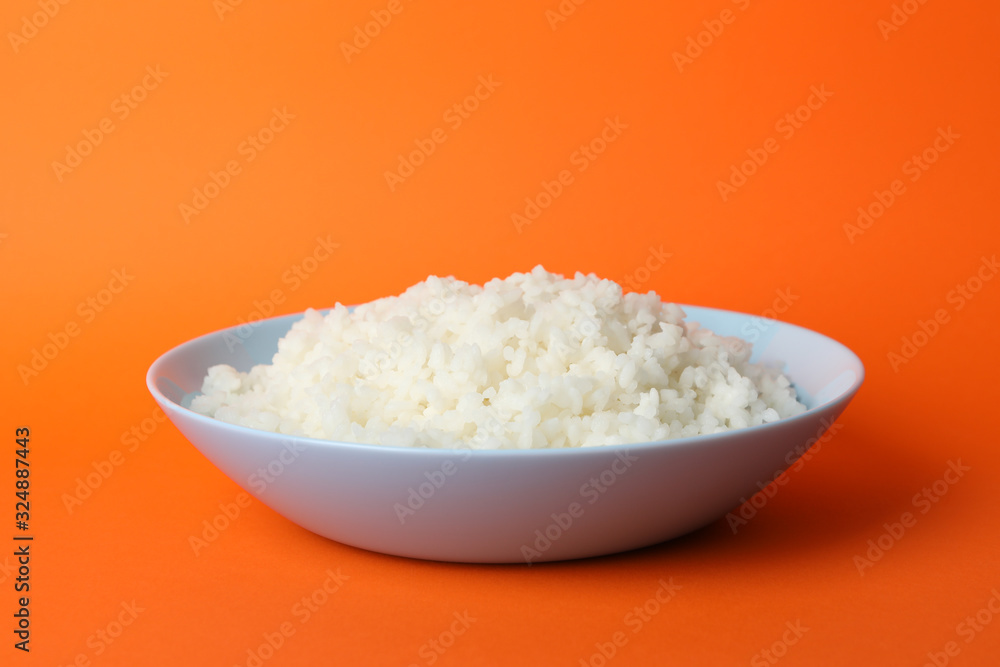 Bowl with boiled rice on orange background, space for text Bowl with boiled rice on orange background, space for text