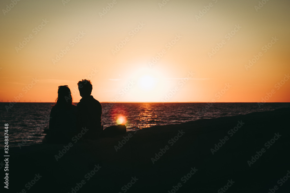 silhouette of couple at the coast at sunset