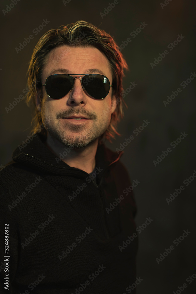 Man wearing dark sunglasses and a black woolen sweater. Man wearing dark sunglasses and a black woolen sweater.