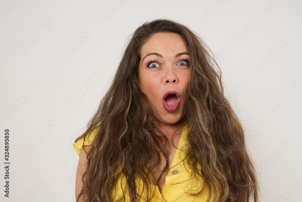 Attractive young woman having stunned and shocked look, with mouth open and jaw dropped, listening to friend's story in full disbelief, exclaiming: Wow, I can't believe this. Surprised girl. Shock